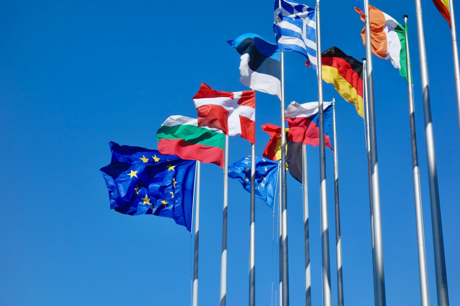 a bunch of European flags that are flying in the air